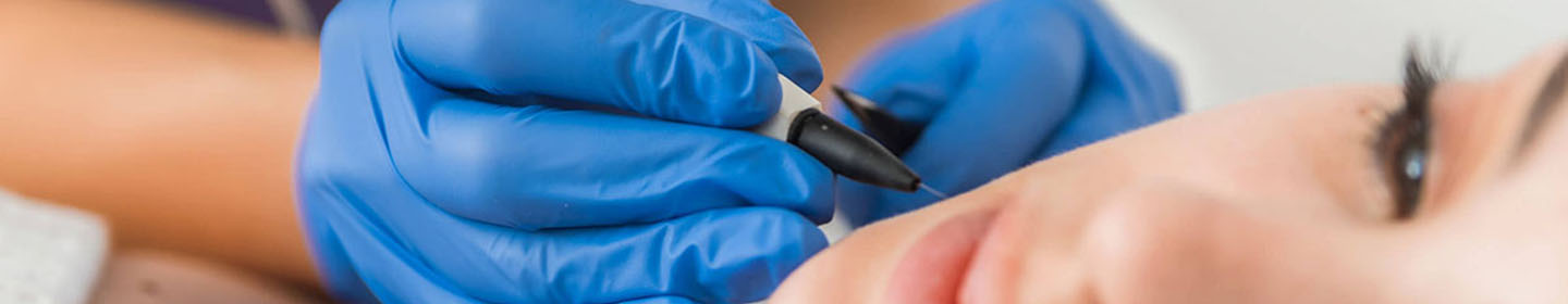 Close-up of a professional performing a facial treatment with a handheld device